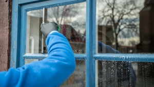 iemand die een raam schoonmaakt